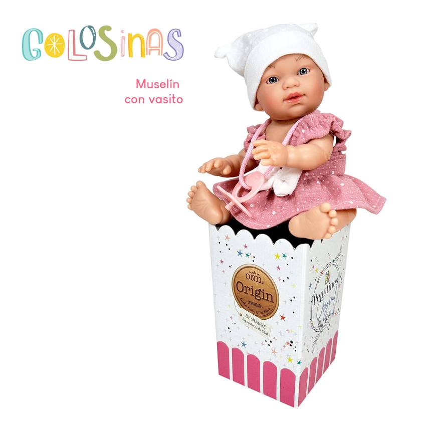 Boneca Golosinas Muselina de vinil 22 cm com copinho, vestida em traje rosa e chapéu branco, sentada em caixa decorativa.